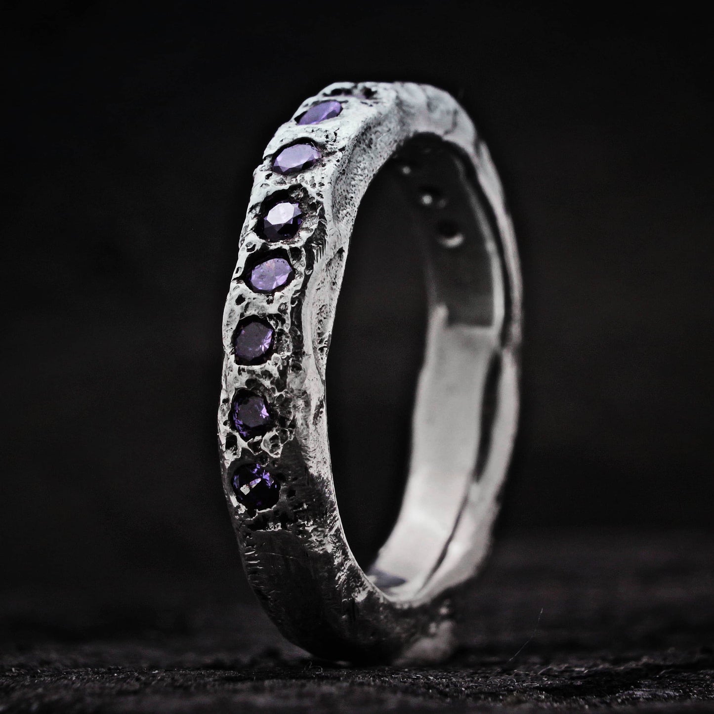 Anillo artesanal de aspecto rústico con cirnitos moradas y plata de ley.