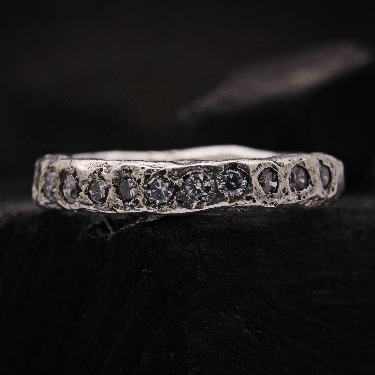 Anillo de plata con circonitas blancas de estilo irregular, joya artesanal de aspecto rústico.
