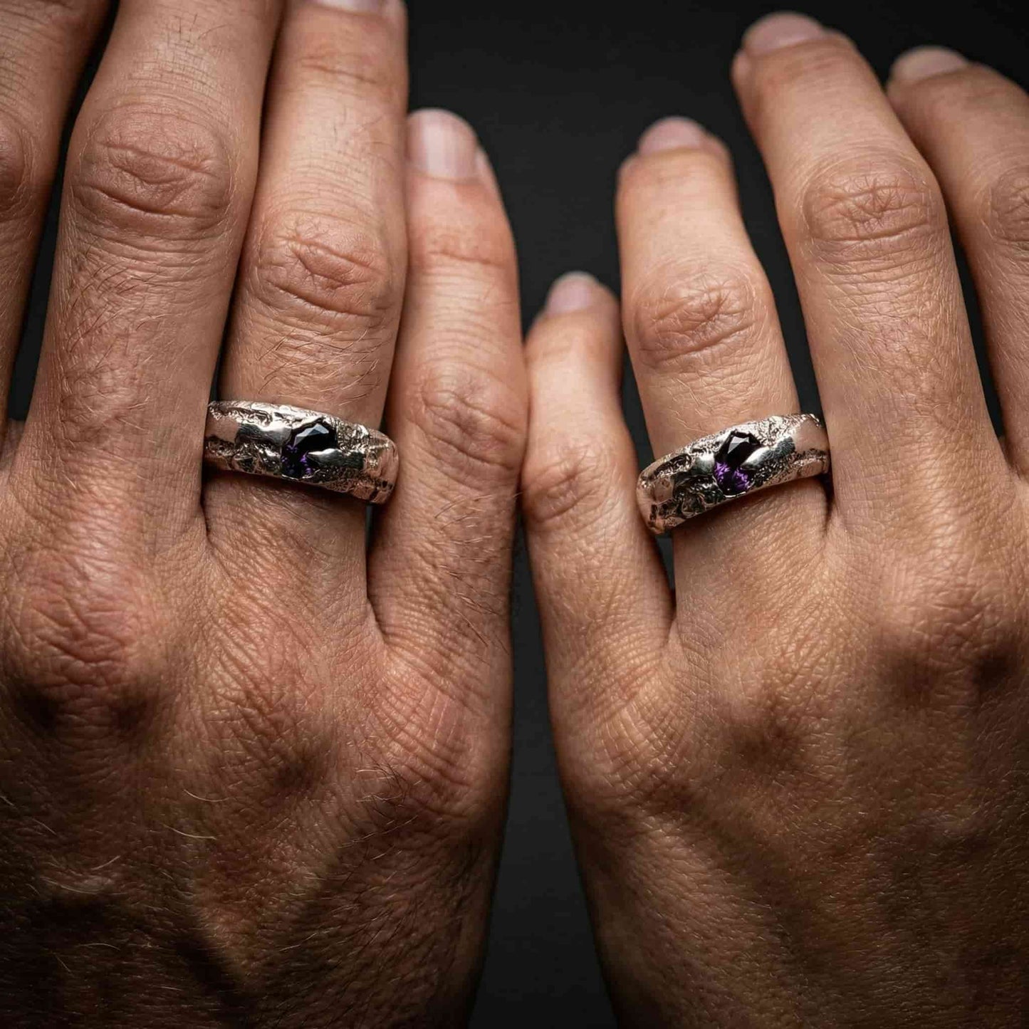 Alianza artesanal con piedra morada puesta en mano de mujer estilo boda boho.