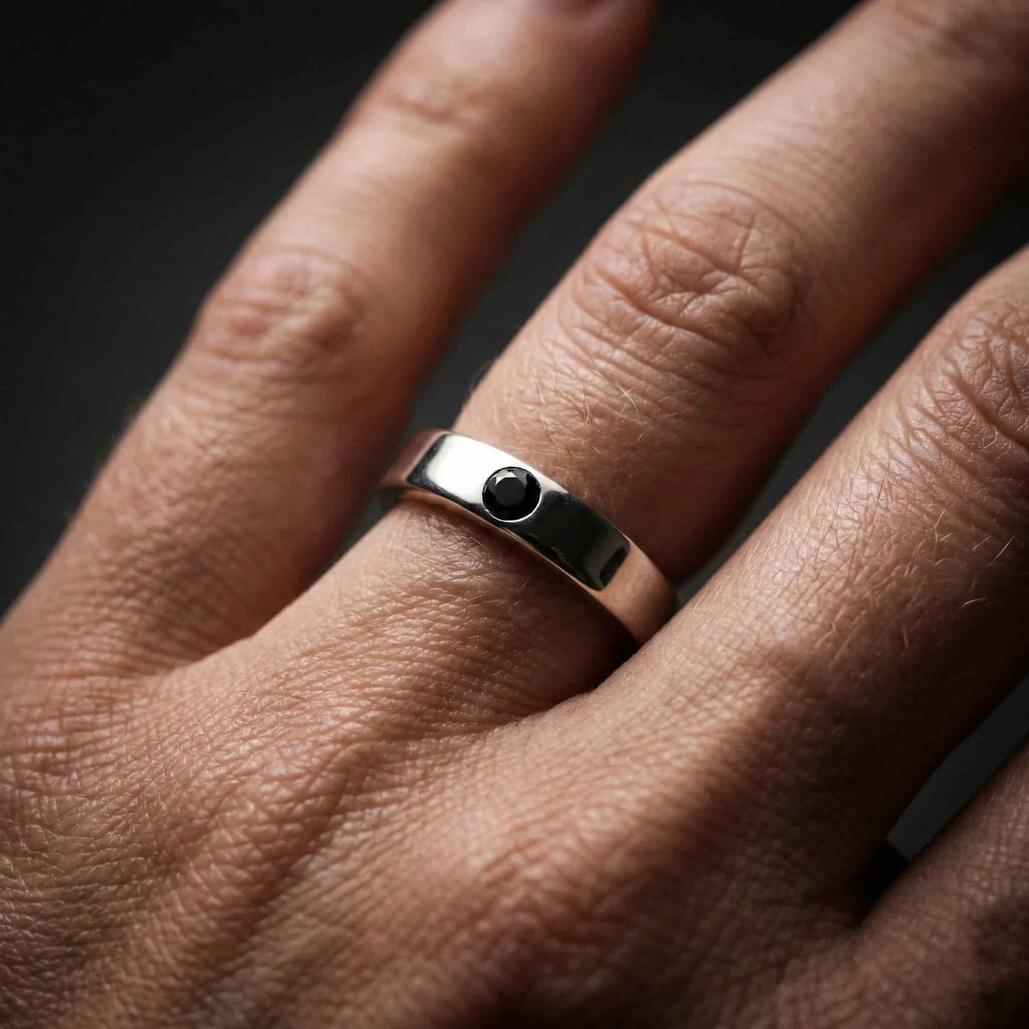 Mano acariciando el anillo de recuerdo íntimo Isil. La joya funeraria más segura para llevar a tu ser querido siempre contigo.
