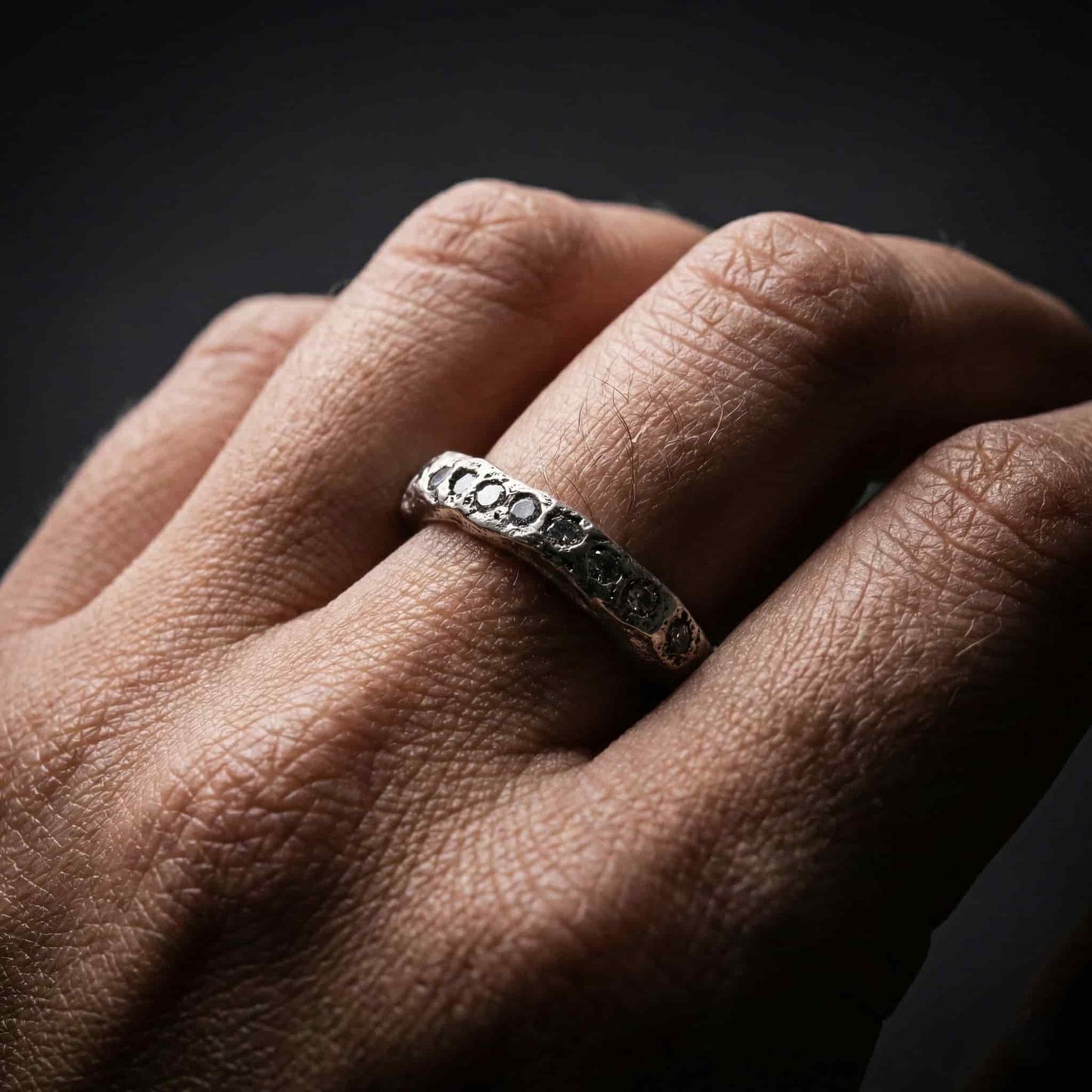 Anillo sin fin modelo Eternity de plata luciendo elegante en mano de mujer.