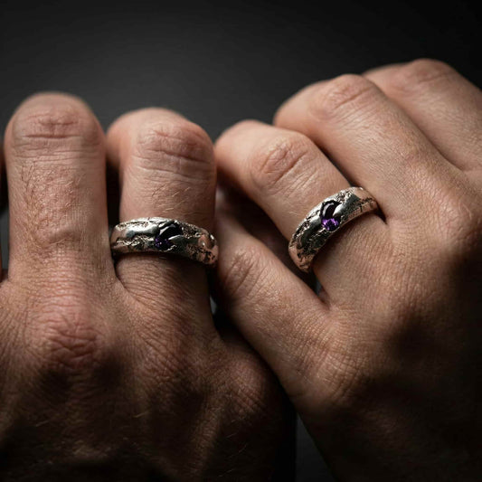 Pareja en boda alternativa con alianzas originales de piedra amatista y textura orgánica.