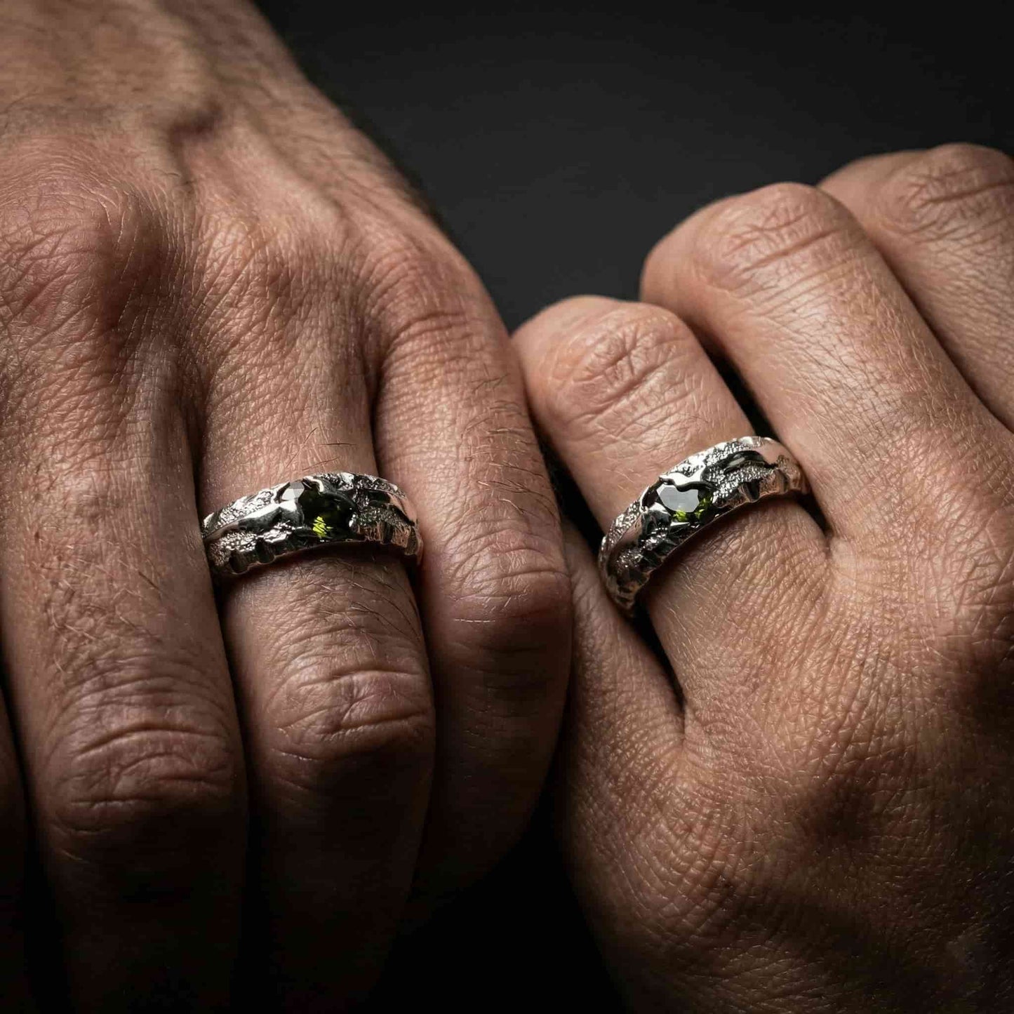 Pareja con alianzas originales de piedras verdes y textura orgánica.