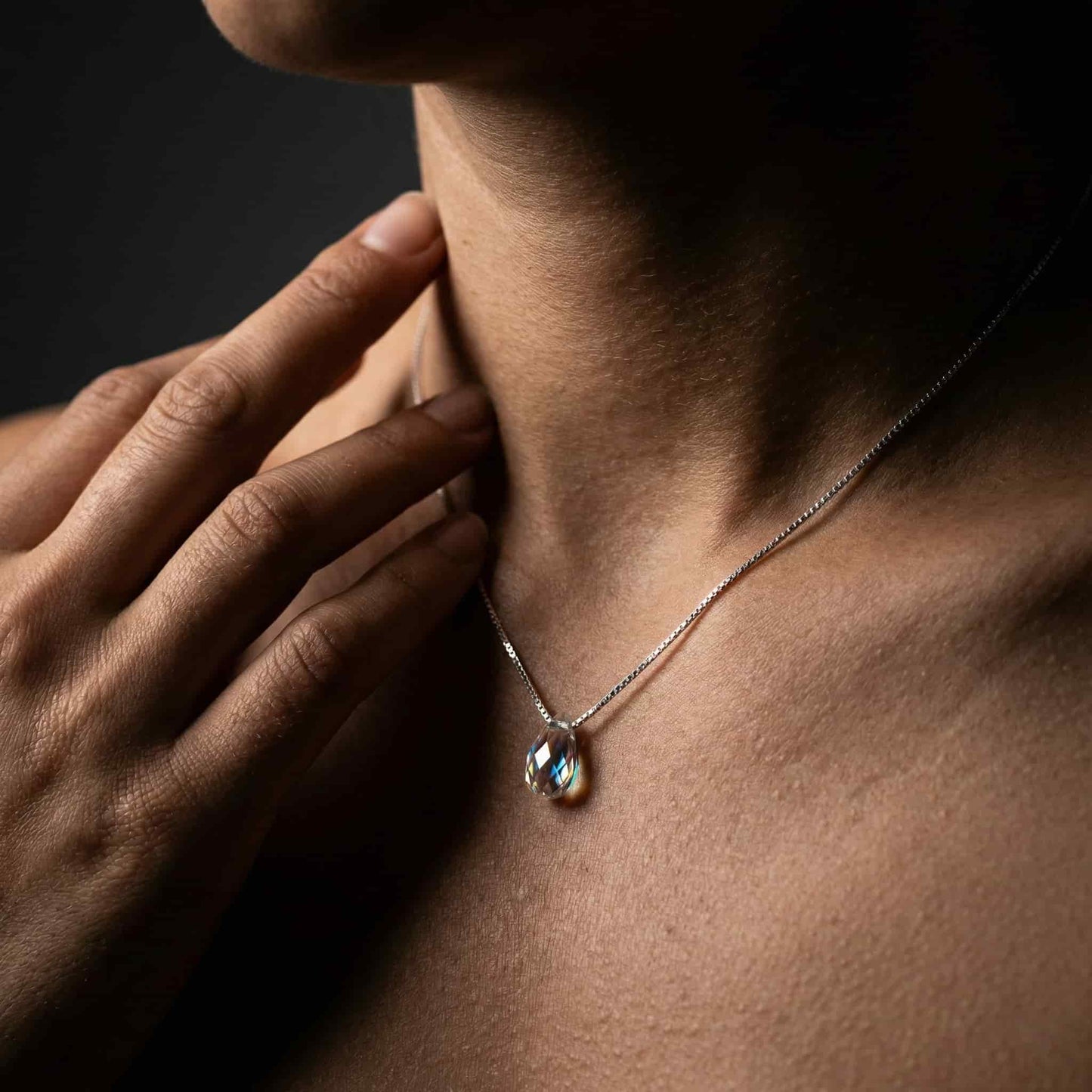 Mujer luciendo collar de plata con lágrima de cristal estilo minimalista.