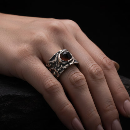 Anillo con cuarzo ahumado en el centro, hecho a mano con textura irregular y acabado oxidado.