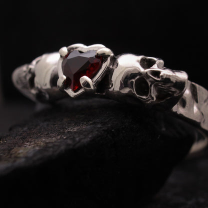 Anillo con dos calaveras y granate en forma de corazón para hombre