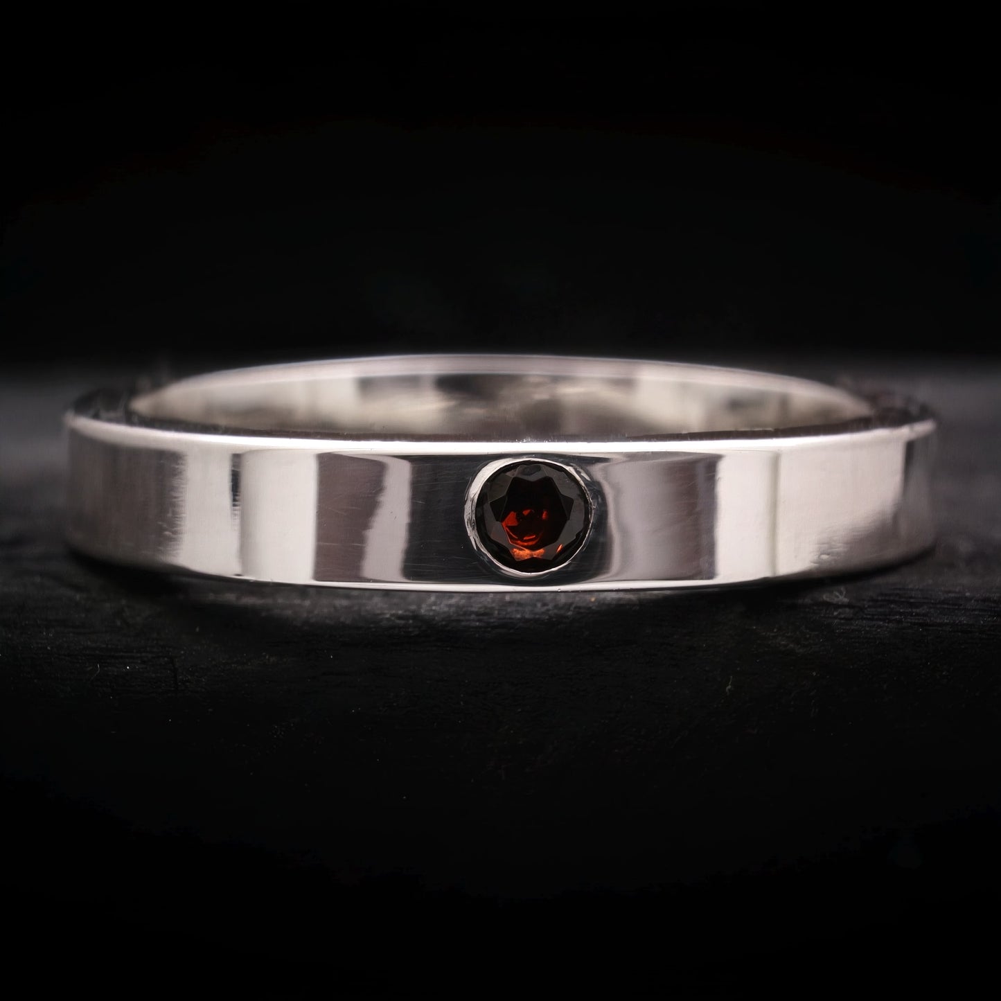 Anillo de compromiso de plata para hombre con granate natural y acabado pulido.