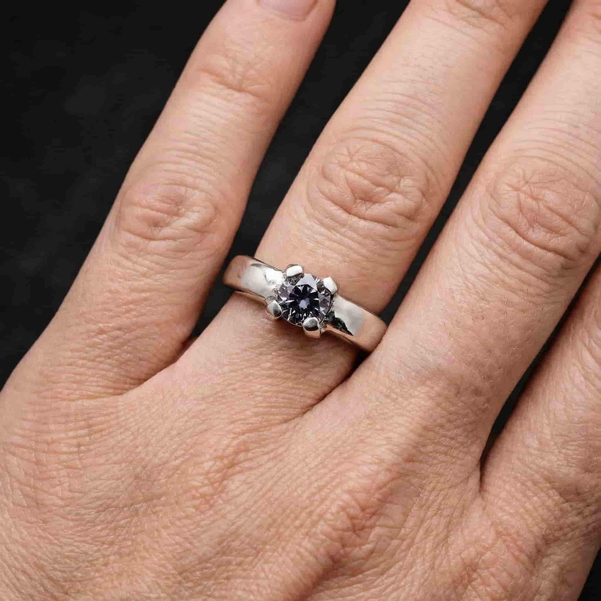 Mujer con anillo solitario de plata y circonita gris