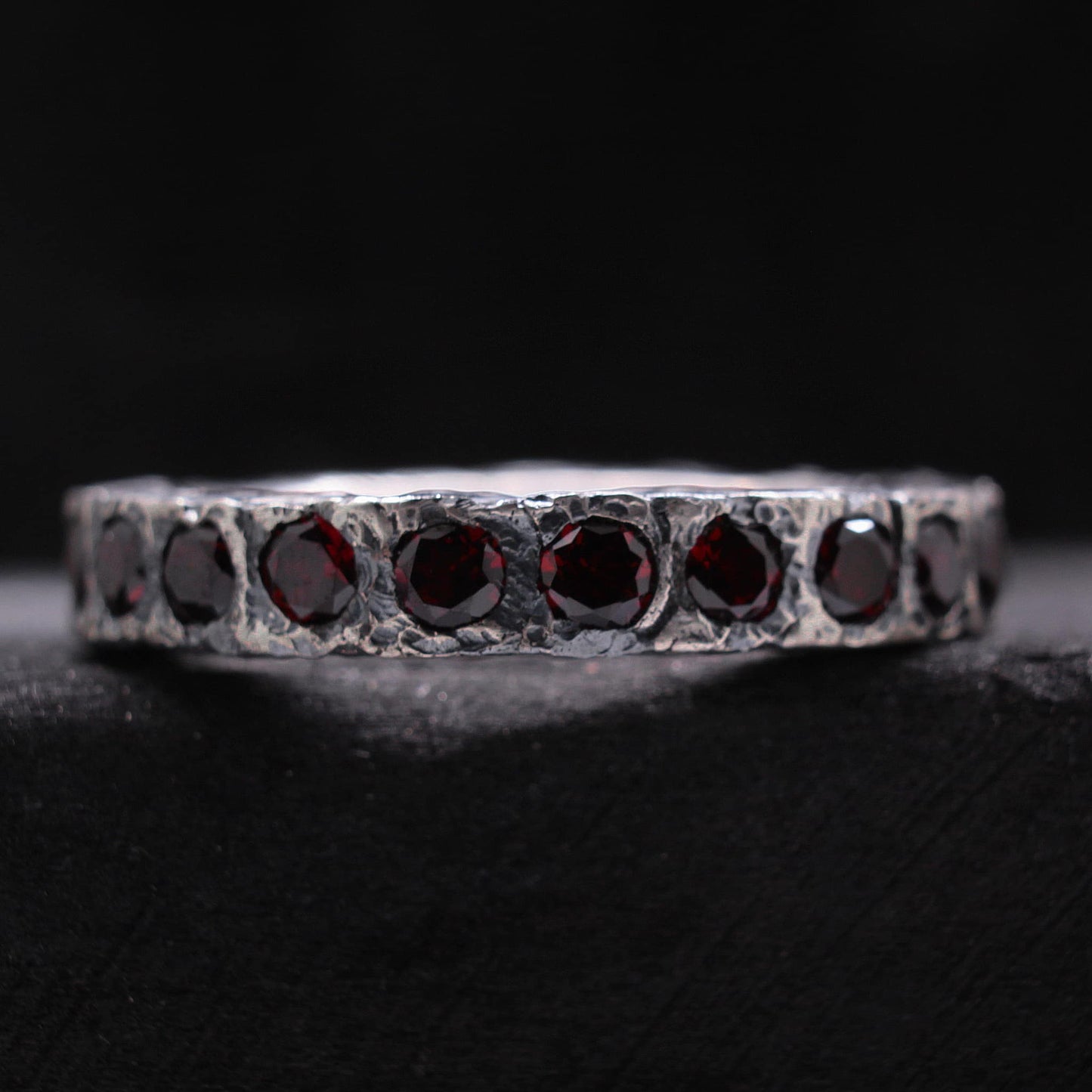 Anillo rustico de plata con acabado irregular y piedras de granate naturales