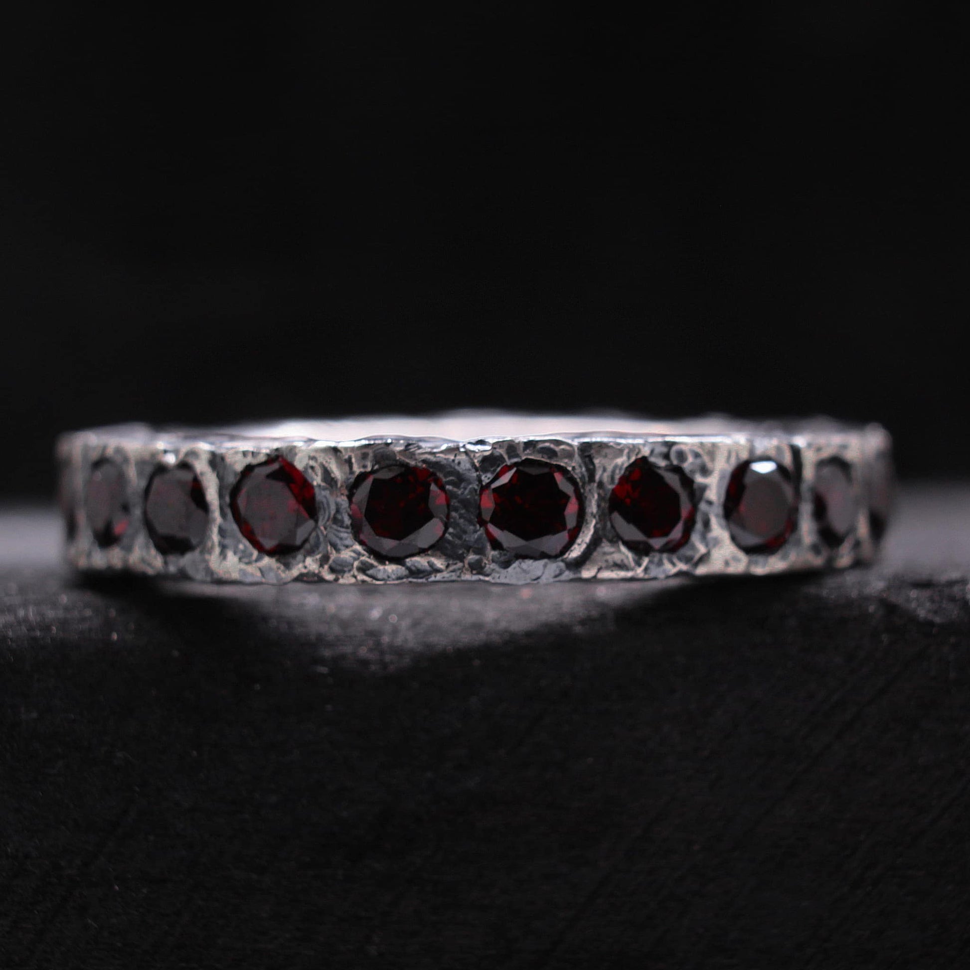 Anillo rustico de plata con acabado irregular y piedras de granate naturales