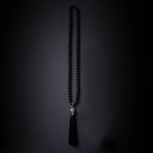 Collar largo de onix mate con colgante dorado de calavera y tasel negro