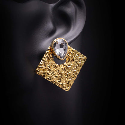 Pendeintes de acero dorados con formna de rombo y cristal. 