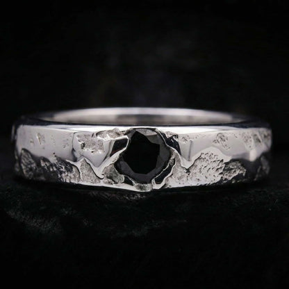 Alianza de plata maciza artesanal con circonita negra y textura rústica de fundición.
