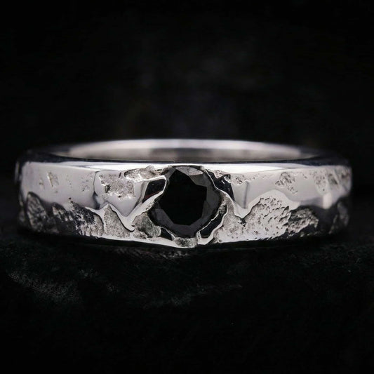 Alianza de plata maciza artesanal con circonita negra y textura rústica de fundición.