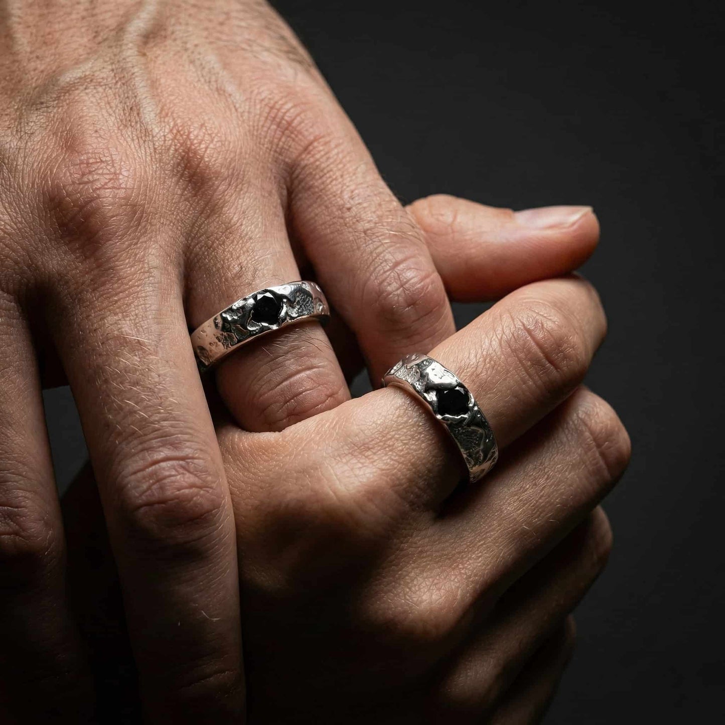 Alianza ancha de 5mm de plata rústica puesta en mano masculina.