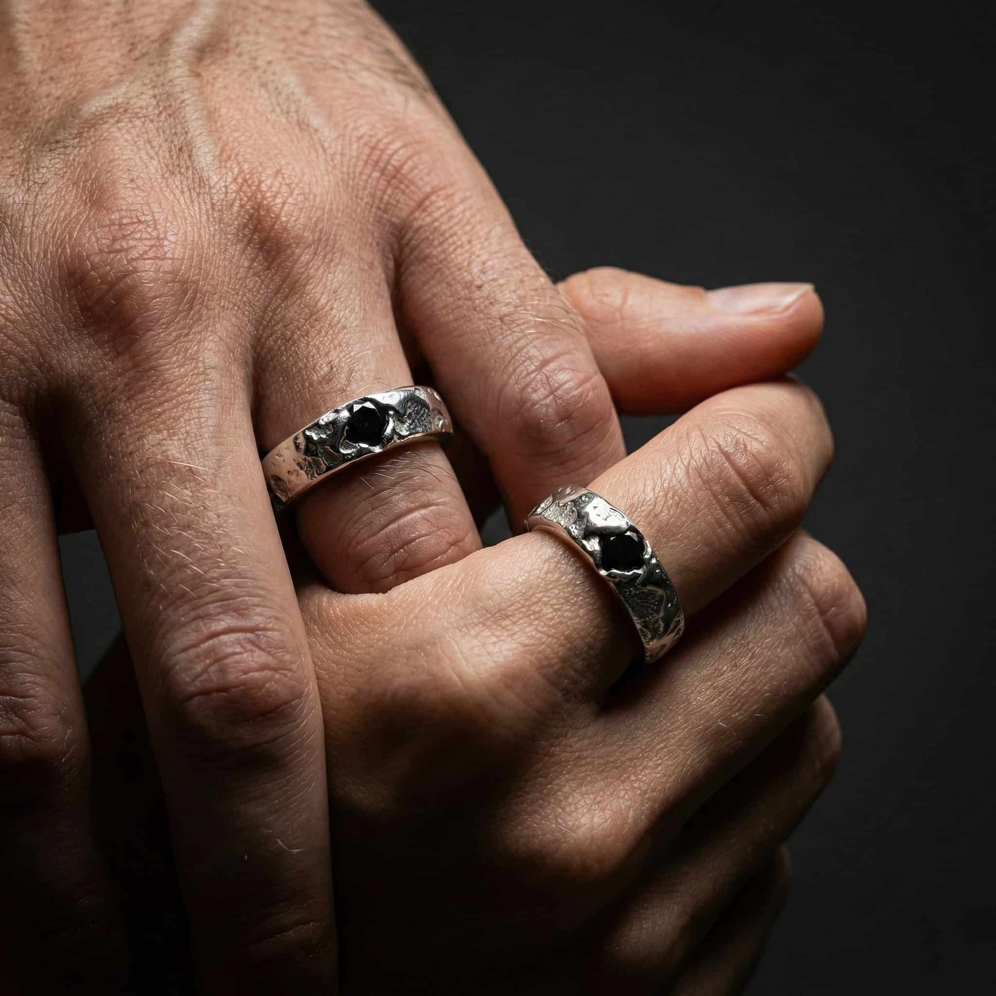 Alianza ancha de 5mm de plata rústica puesta en mano masculina.