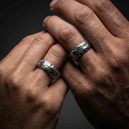 Alianza oxidada estilo rústico puesta en la mano con luz natural.