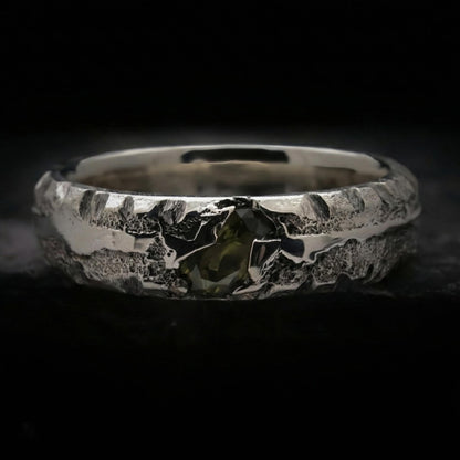 Alianza de plata maciza con textura rústica y circonita color verde oliva. Anillo de 5mm de ancho y 3mm de grosor hecho a mano por fundición en arena.