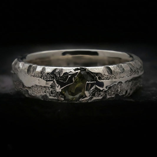 Alianza de plata maciza con textura rústica y circonita color verde oliva. Anillo de 5mm de ancho y 3mm de grosor hecho a mano por fundición en arena.