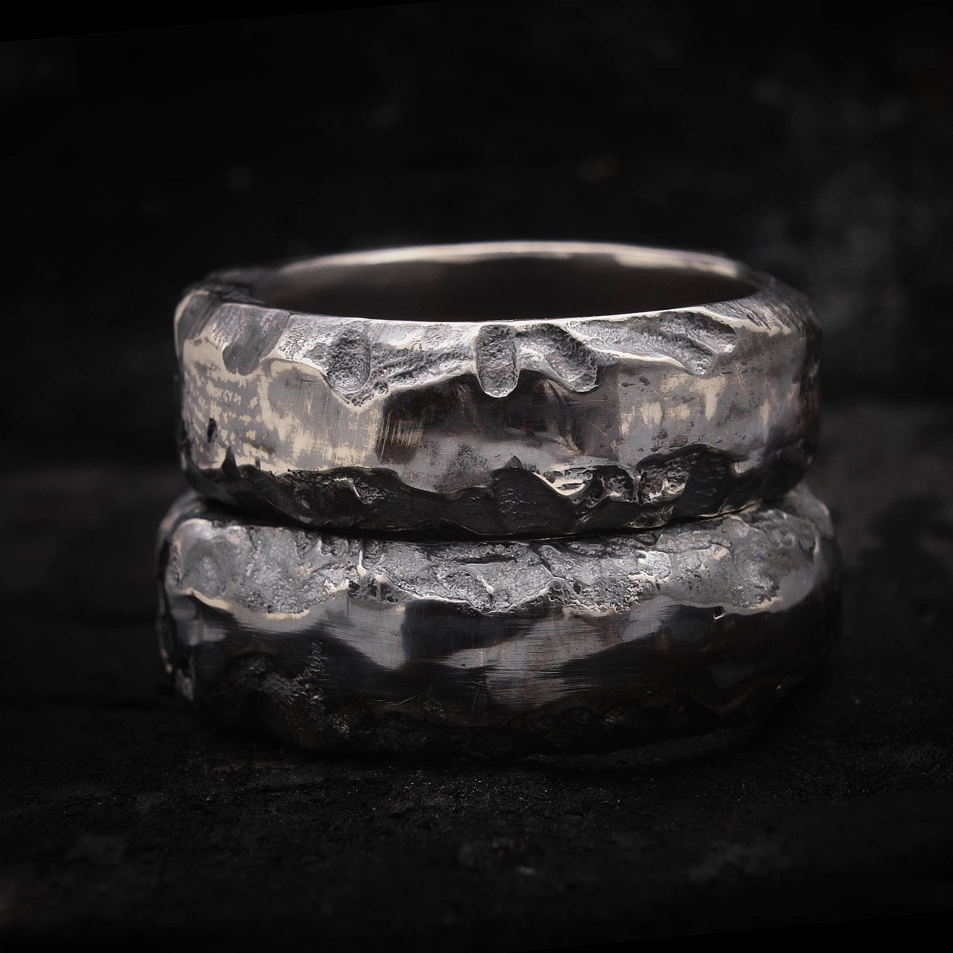 Alianza de boda rústica de plata oxidada con textura irregular de fundición en arena.