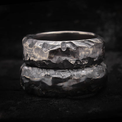 Alianza de boda rústica de plata oxidada con textura irregular de fundición en arena.