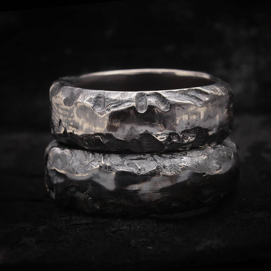 Alianza de boda rústica de plata oxidada con textura irregular de fundición en arena.