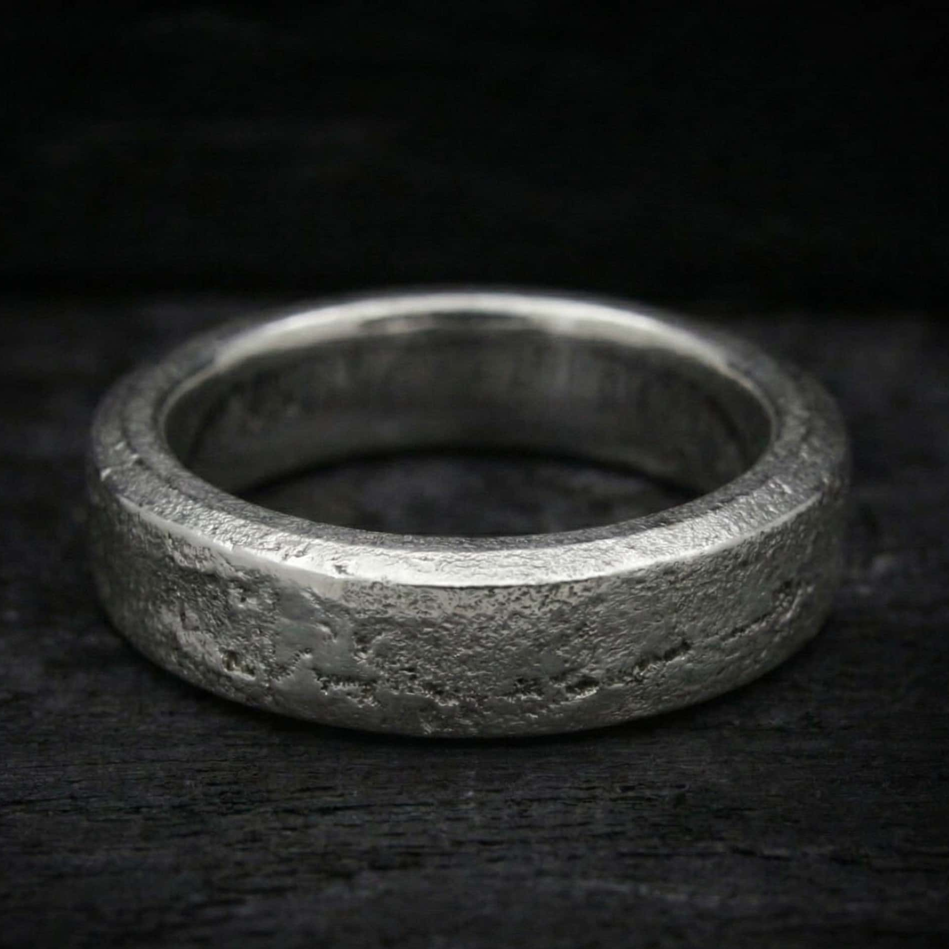 Anillo Lur de plata maciza forjada en arena con cenizas selladas en su interior. Textura rústica y orgánica.