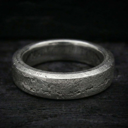 Anillo Lur de plata maciza forjada en arena con cenizas selladas en su interior. Textura rústica y orgánica.