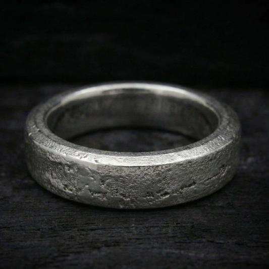 Anillo Lur de plata maciza forjada en arena con cenizas selladas en su interior. Textura rústica y orgánica.