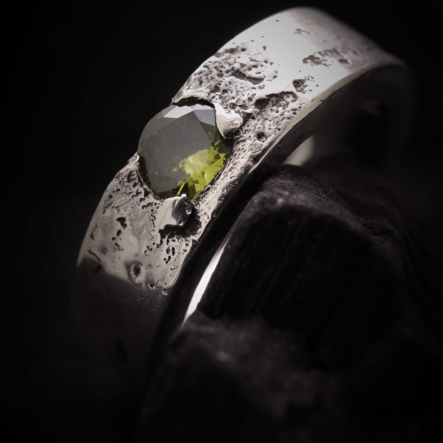 Vista frontal del anillo de plata de 6mm para hombre con circonita peridoto central.