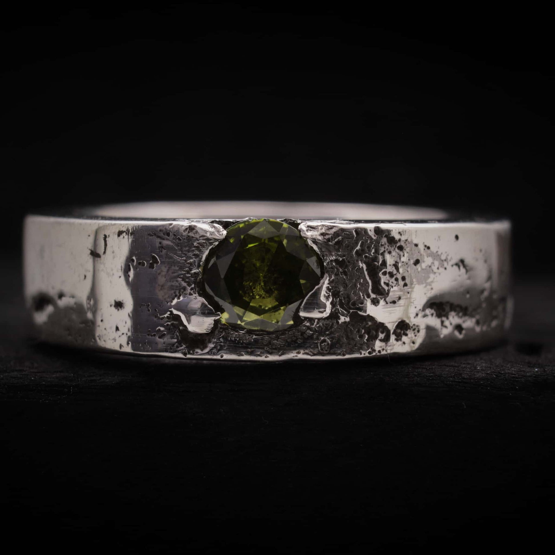 Anillo de hombre de plata rústica con circonita peridoto verde engastada, textura de fundición.