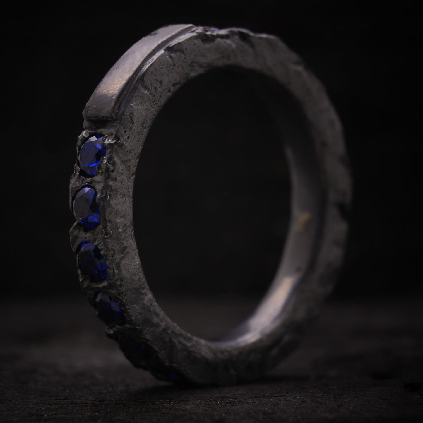 Anillo de plata para hombre diseño macizo con espinelas azules y textura rústica.
