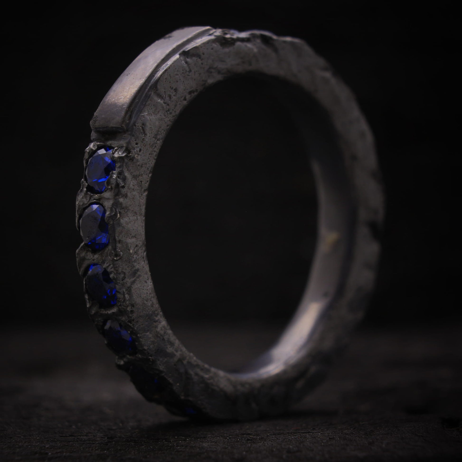 Anillo de plata para hombre diseño macizo con espinelas azules y textura rústica.