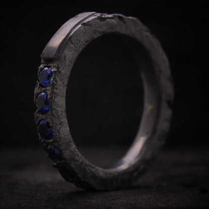 Anillo de plata para hombre diseño macizo con espinelas azules y textura rústica.