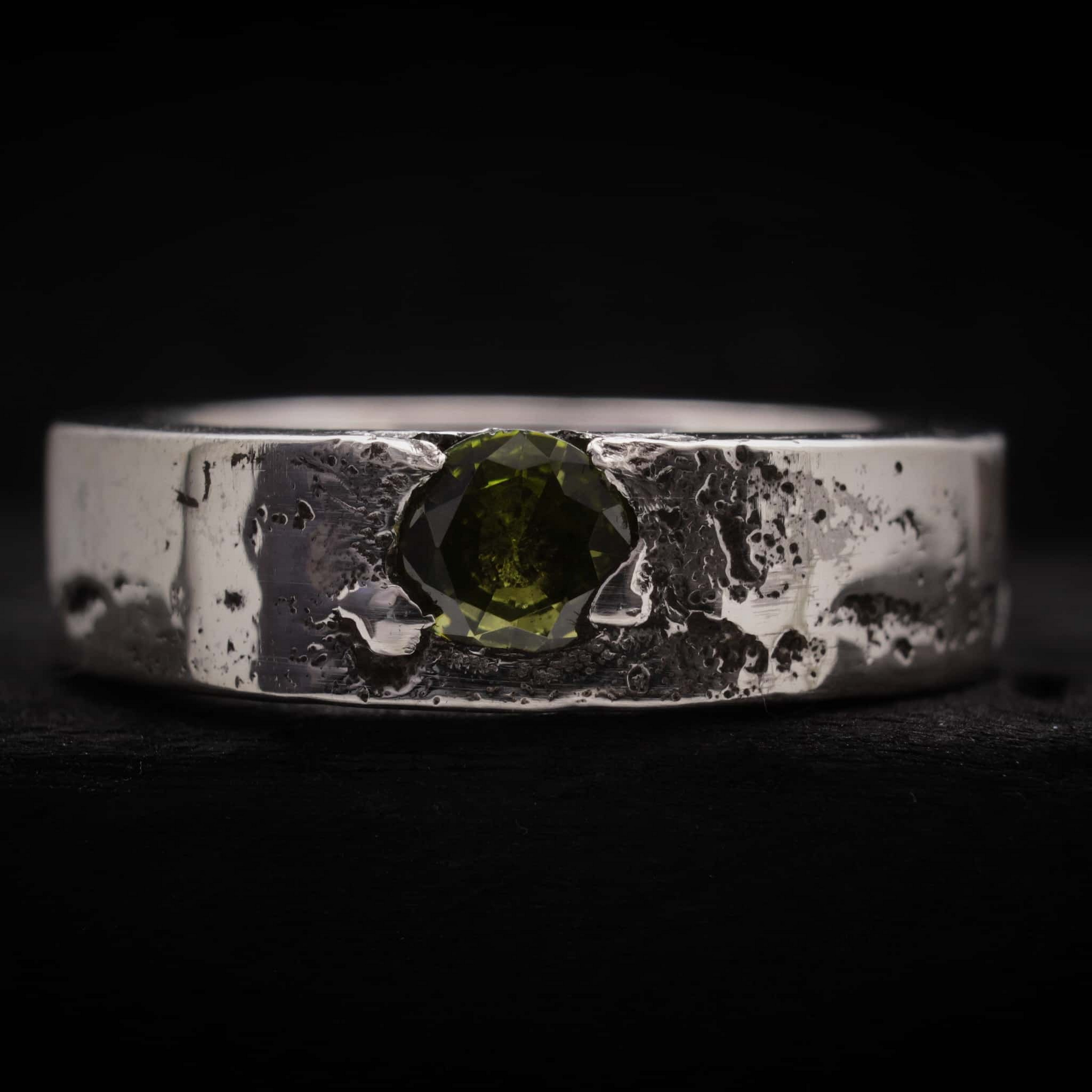 Anillo de la colección Legado con cenizas y circonita verde peridoto engastada.