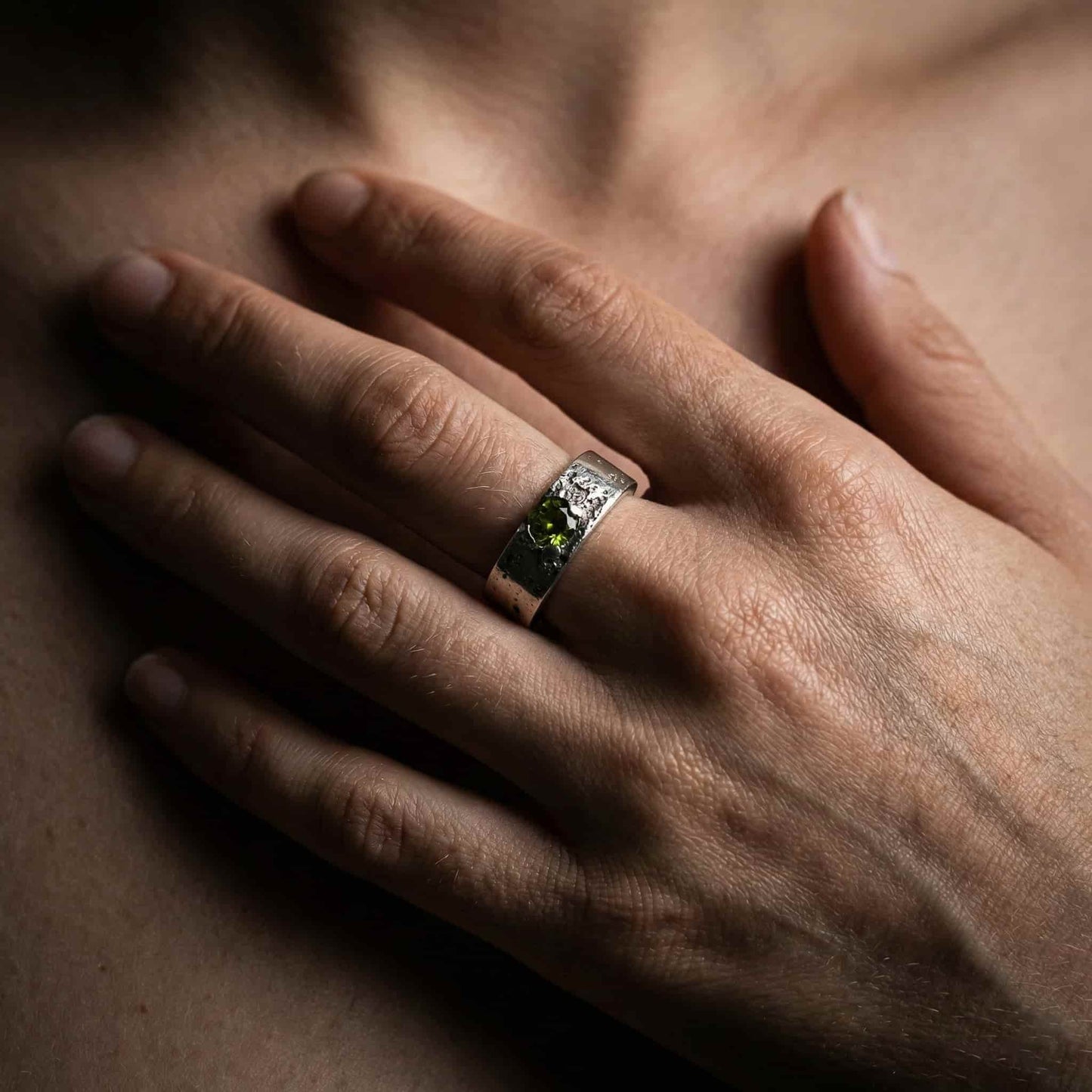 Mano de modelo luciendo el anillo de la colección Legado con cenizas y circonita peridoto en el dedo.