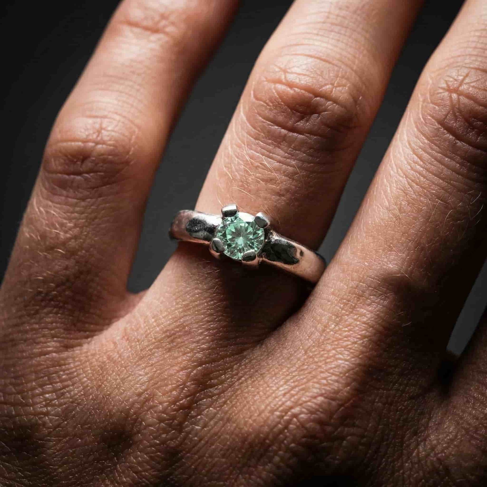 Detalle de anillo de compromiso solitario en plata de ley con acabado rústico texturizado.