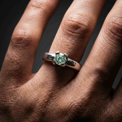 Detalle de anillo de compromiso solitario en plata de ley con acabado rústico texturizado.