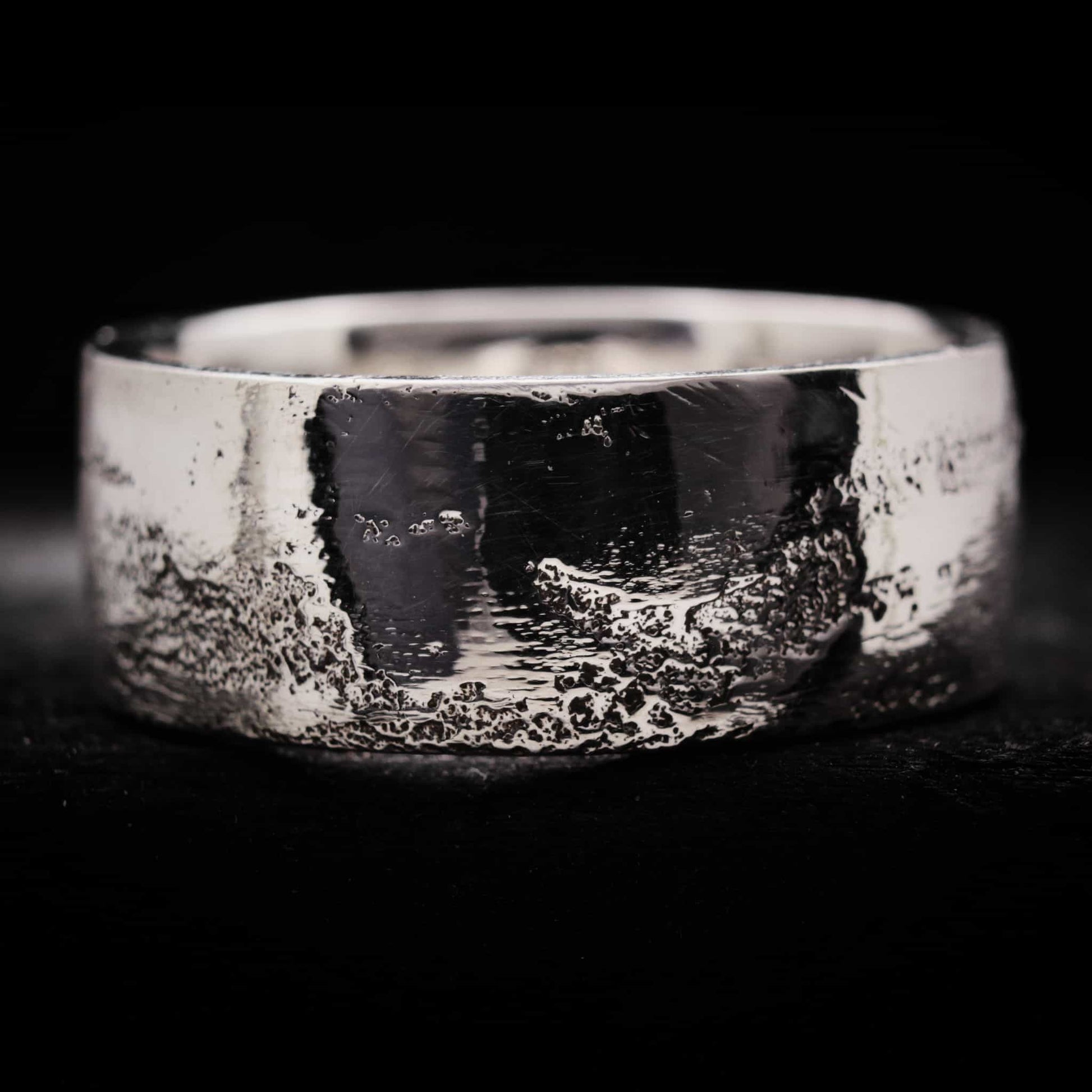 Anillo de plata de 10mm de ancho para hombre con acabado textura arena irregular y superficie brillante.