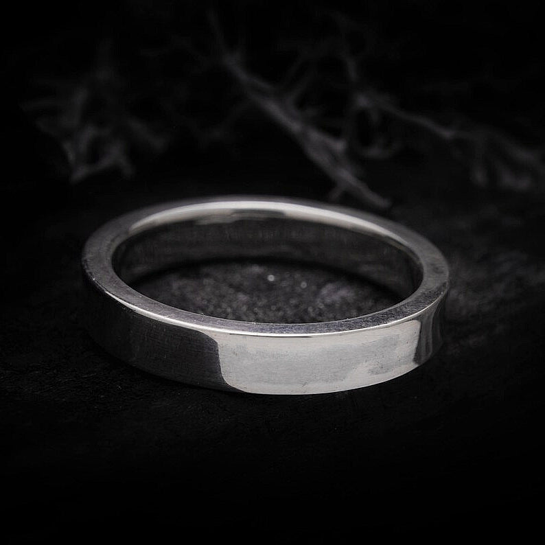 Detalle de anillo de plata con corte recto y perfil geométrico moderno.
