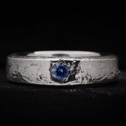 Anillo de plata para hombre forjado en arena con una circonita azul brillante incrustada