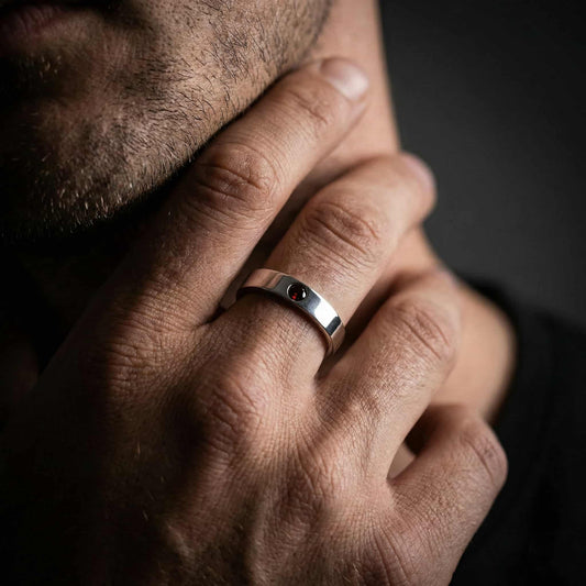 Anillo de plata para hombre diseño minimalista con piedra granate central.