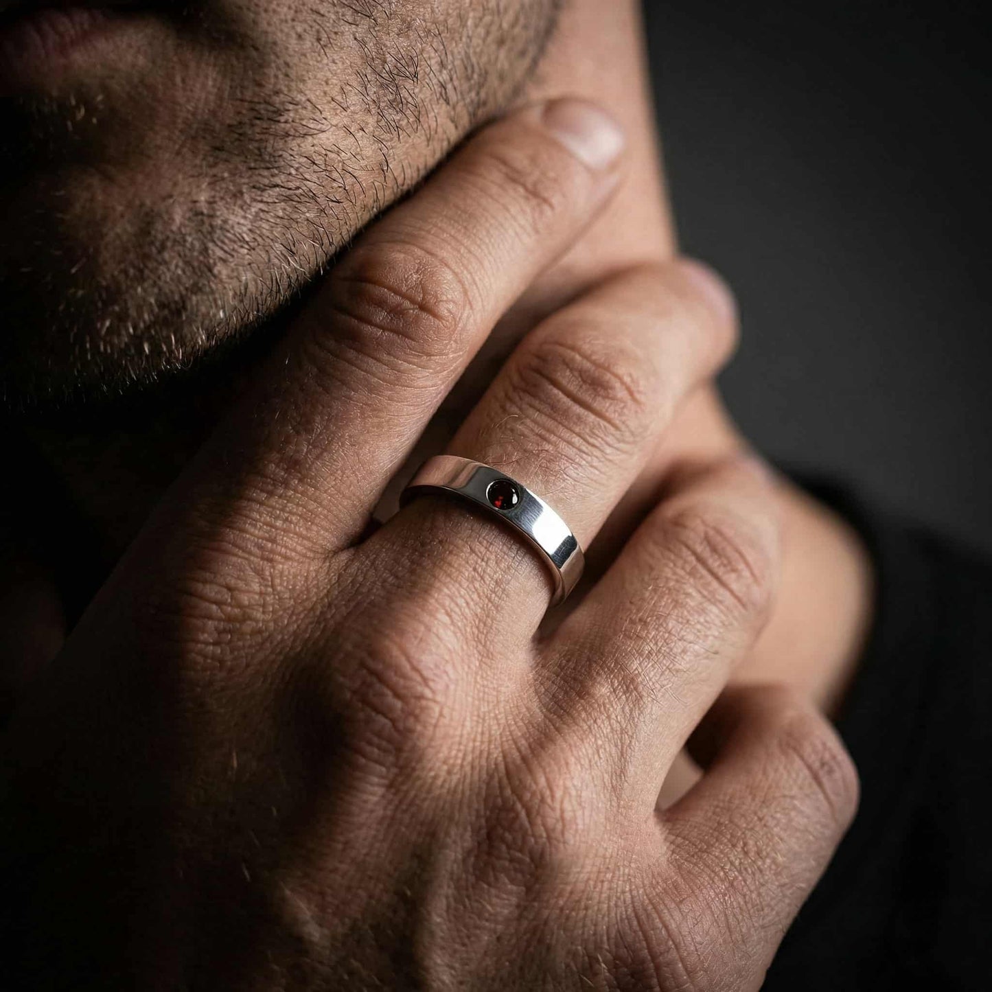 Anillo de plata para hombre diseño minimalista con piedra granate central.