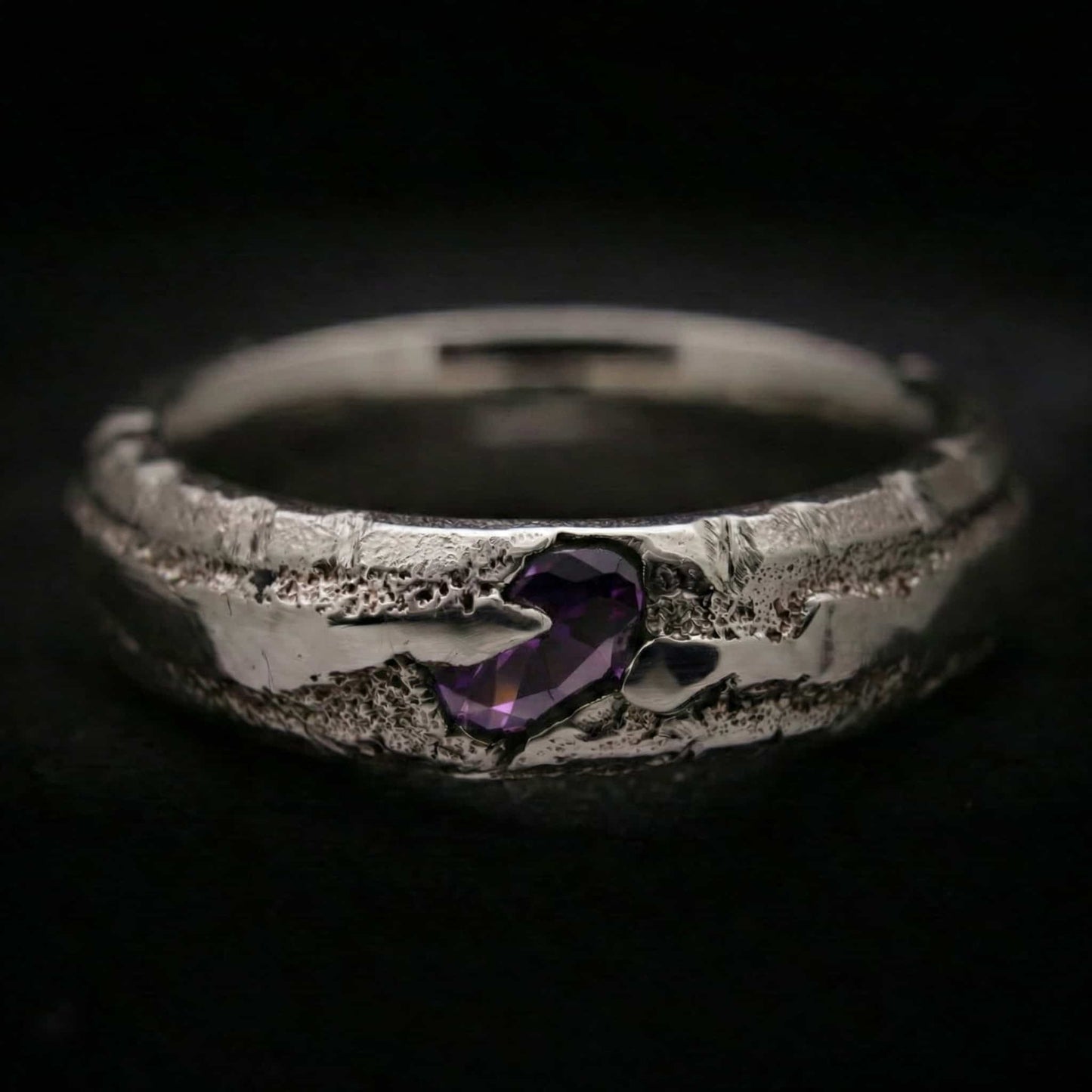 Detalle anillo de plata para hombre artesanal con circonita morada color amatista oscura.