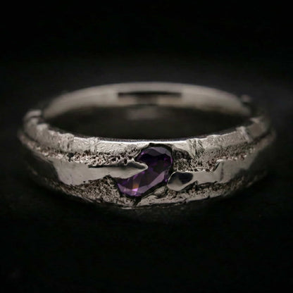 Detalle anillo de plata para hombre artesanal con circonita morada color amatista oscura.