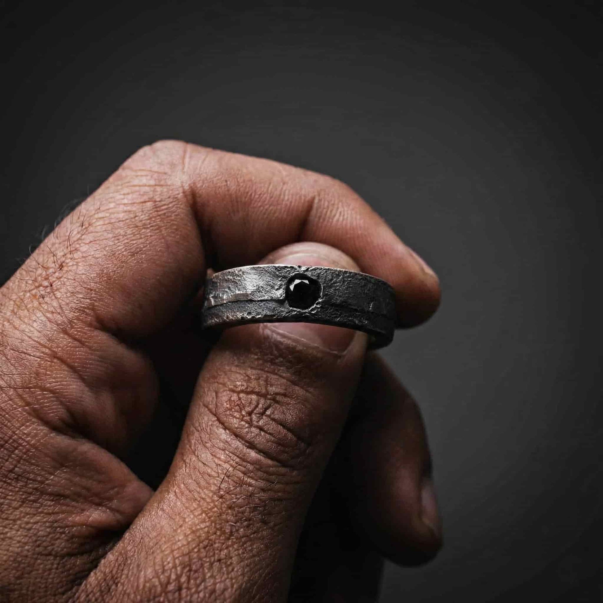 Anillo de plata para hombre diseño rustico con una pequeña circonita negra incrustada