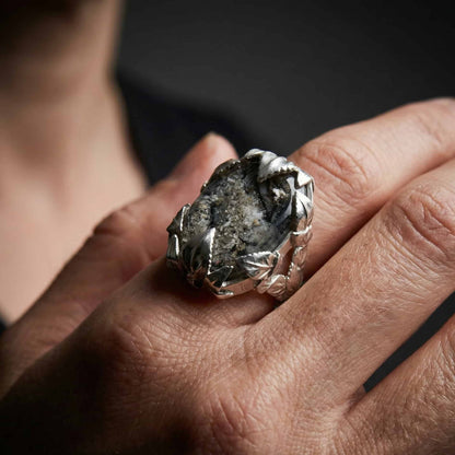 Mano luciendo un anillo personalizado con cenizas y resina.