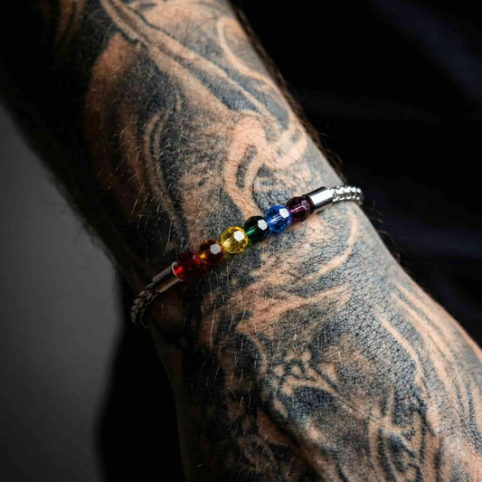 Brazalete LGBT plateado de acero inoxidable resistente al agua sobre fondo neutro.