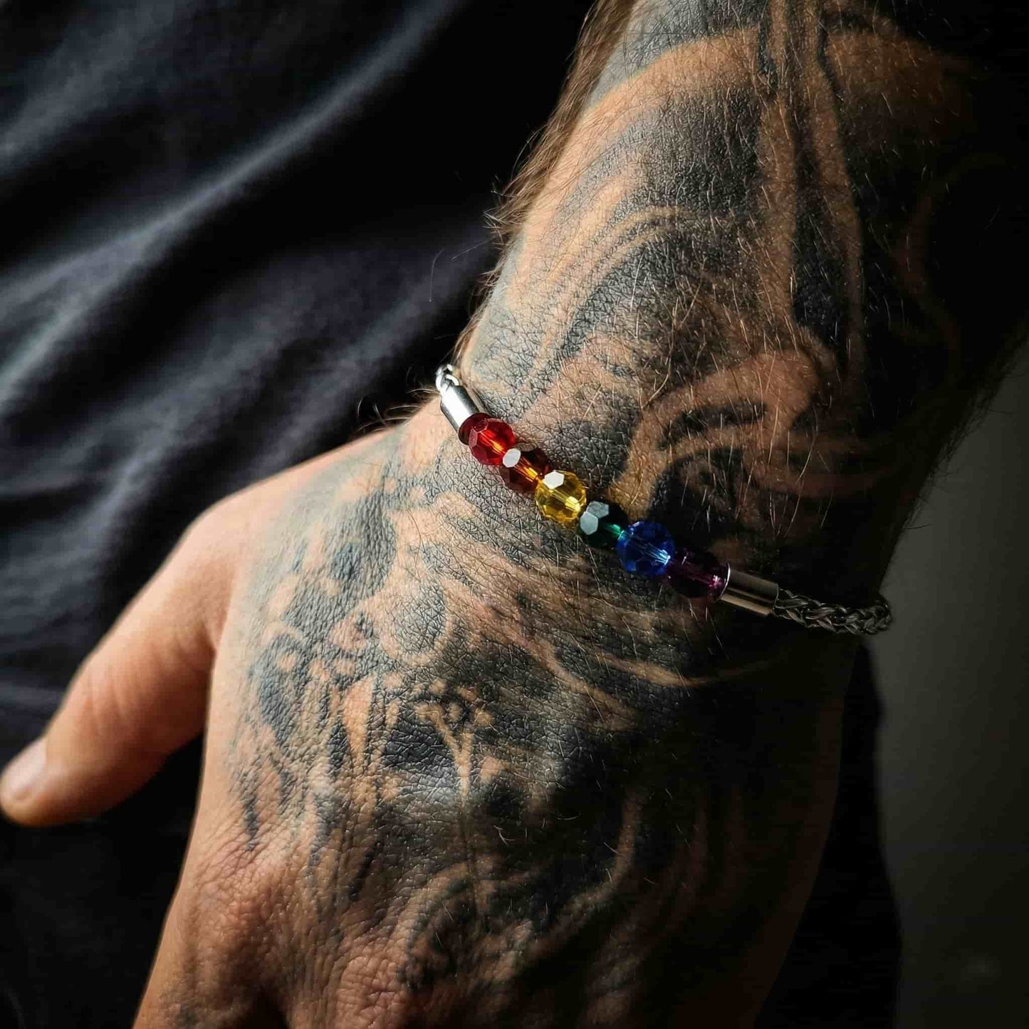 Primer plano de los cristales bandera gay incrustados en placa de acero inoxidable.