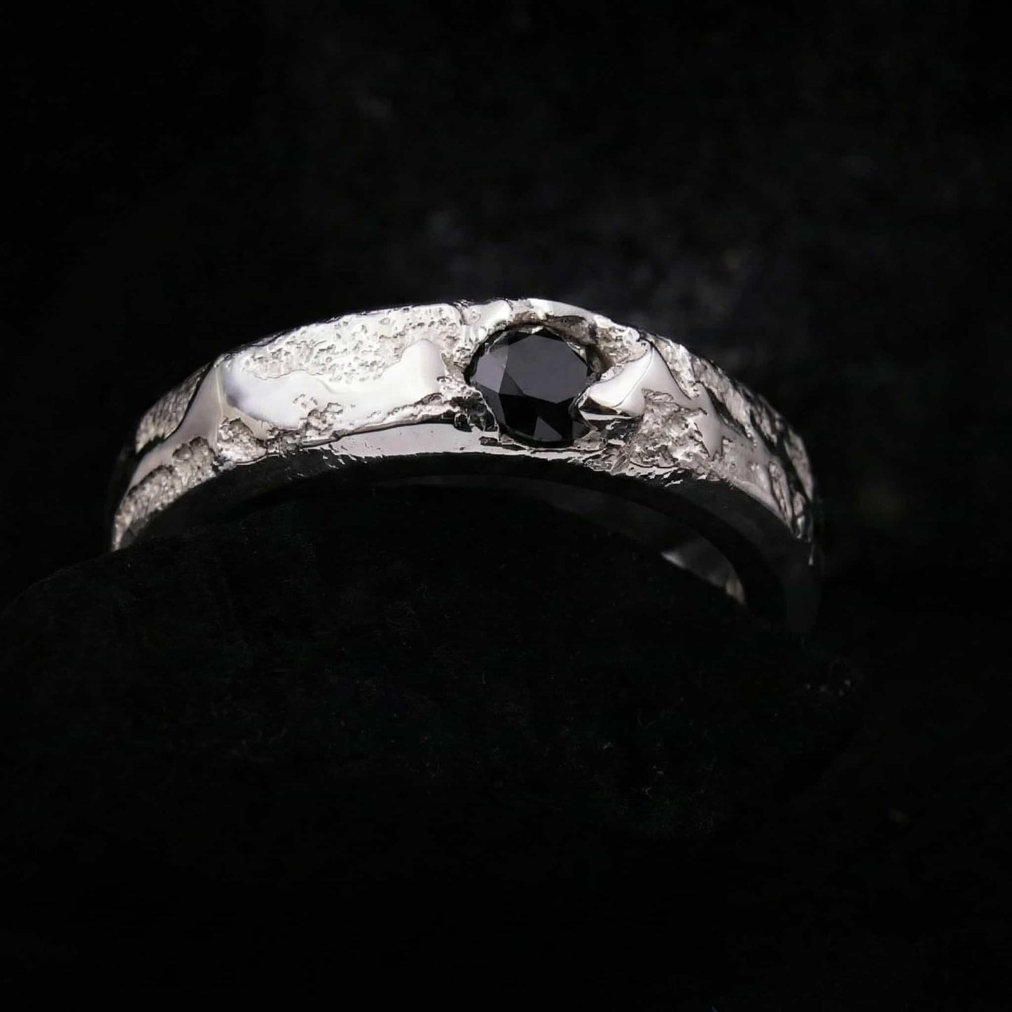 Detalle macro del engarce de la circonita negra talla brillante en el anillo de plata forjada a mano.